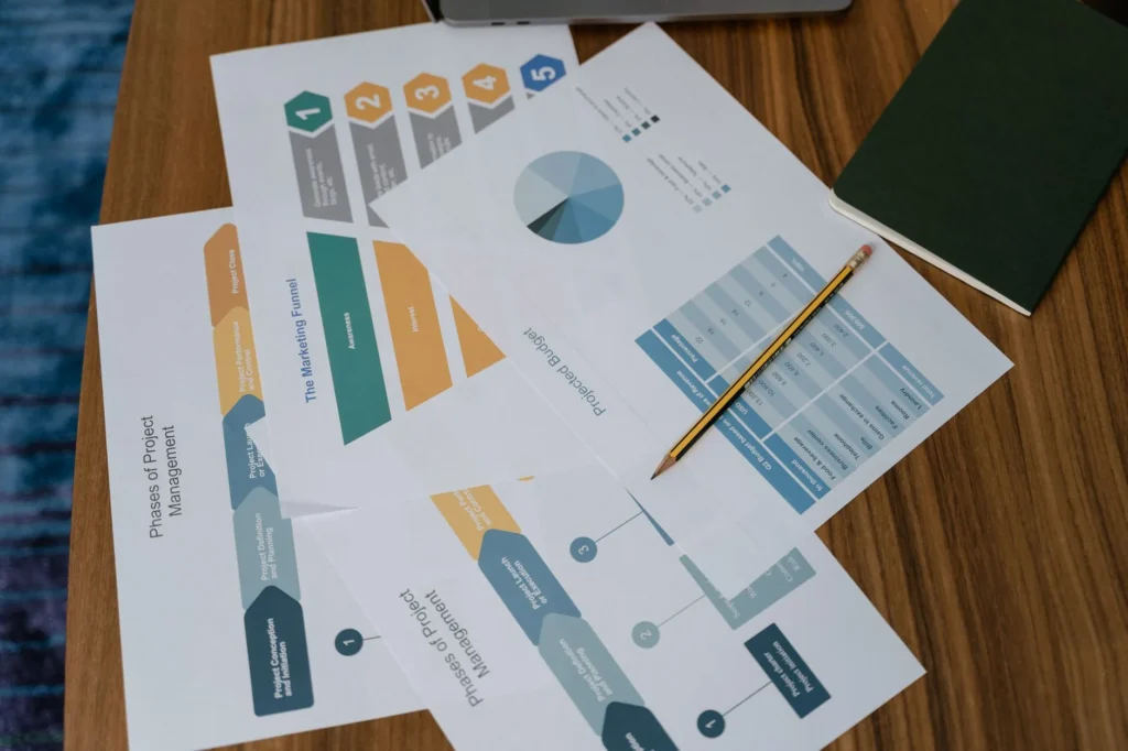 Study notebook and laptop open showing PMP exam domain weightings for 2026