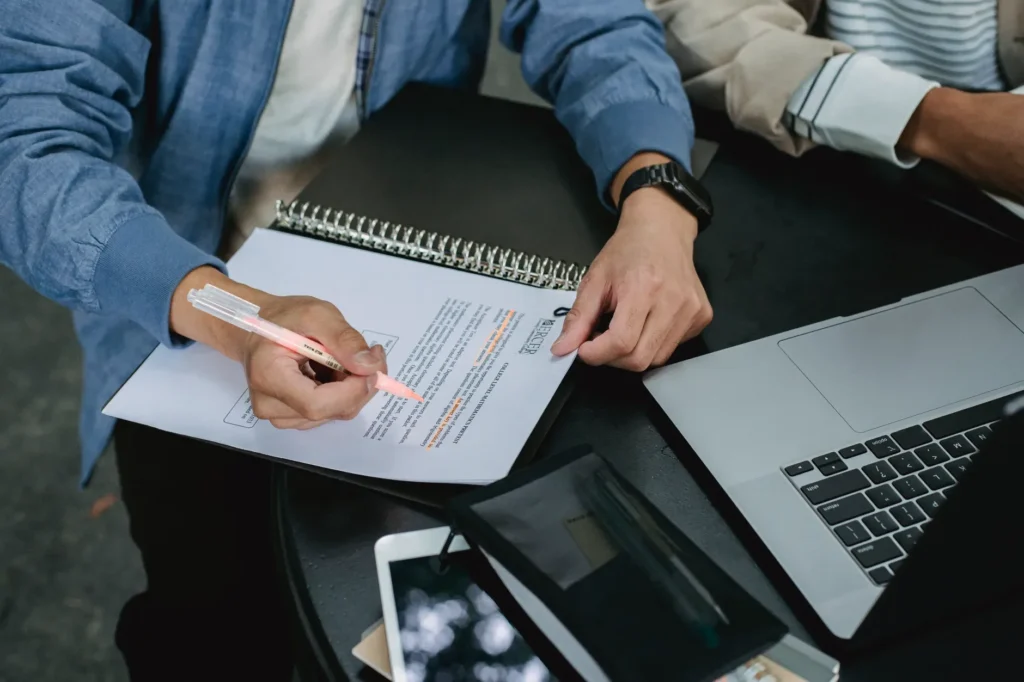IT professional reviewing cloud certification study materials at a desk with laptop and notes