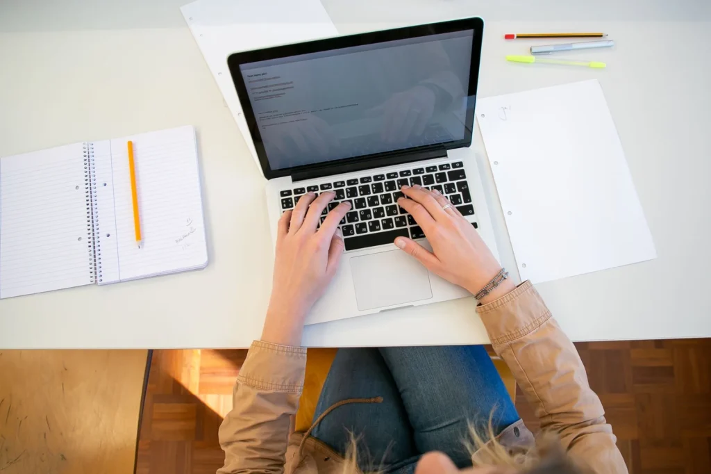 IT professional reviewing official certification exam path guides on a laptop